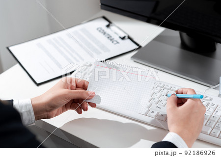 Businesswoman Holding Pen And Important Message Wtitten On Paper On Desk With Computer, Clipboard And Notes. Crutial News Presented On Notepad On Table With Keyboard And Pc. Businesswoman Holding Pen And Important Message Wtitten On Paper On Desk With Computer, Clipboard And Notes. Crutial News Presented On Notepad On Table With Keyboard And Pc. 92186926