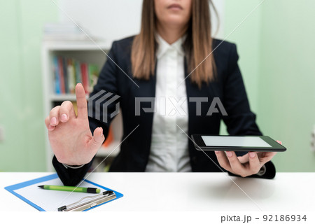 Businesswoman Holding Tablet With One Hand And Pointing Important Ideas With One Finger. Woman With Phone Showing Recent Updates. Executive Displaying Late News. 92186934