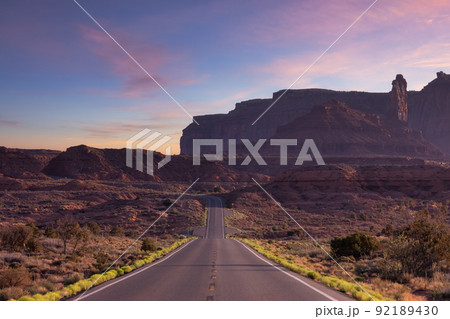Scenic Road in the Dry Desert with Red Rocky Mountains in Backgroun 92189430