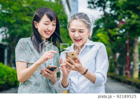 スマホを使う親子(歳の離れた女性たち) スマホを使う親子(歳の離れた女性たち) 92189525