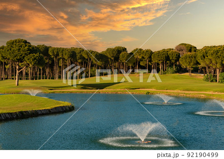 View of the golf course which is located behind the lake with fountains 92190499