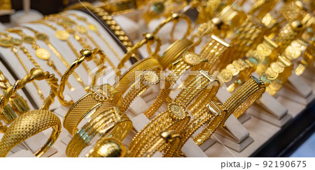 Golden luxury bracelets on stand in jewelry shop 92190675