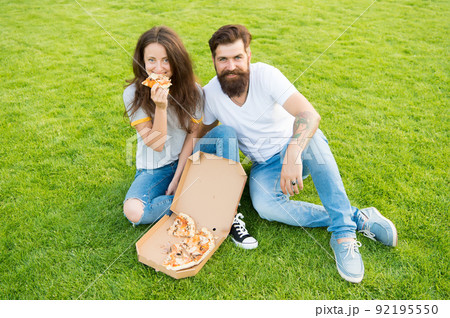They are sharing pizza and eating. couple in love dating. 92195550