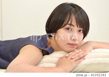 室内でくつろぐ紺のワンピースを着た透明感のある若い女性 92202282