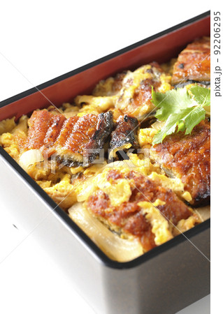 鰻の蒲焼きを卵でとじて三つ葉を乗せた鰻玉重を白背景で撮影 92206295