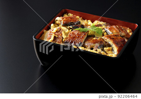 鰻の蒲焼きを卵でとじて三つ葉を乗せた鰻玉重を黒背景で撮影 鰻の蒲焼きを卵でとじて三つ葉を乗せた鰻玉重を黒背景で撮影 92206464