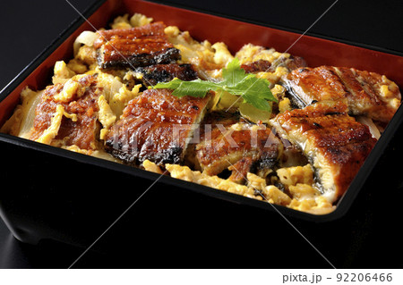 鰻の蒲焼きを卵でとじて三つ葉を乗せた鰻玉重を黒背景で撮影 鰻の蒲焼きを卵でとじて三つ葉を乗せた鰻玉重を黒背景で撮影 92206466