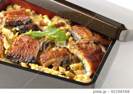 鰻の蒲焼きを卵でとじて三つ葉を乗せた鰻玉重を白背景で撮影 92206566