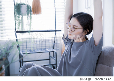 明るい室内でストレッチ体操をするワンピース姿の日本人女性 92207332