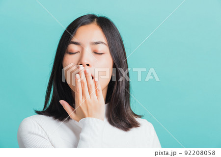 Portrait female bored yawning tired covering mouth with hand Portrait female bored yawning tired covering mouth with hand 92208058