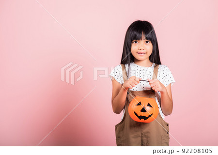 Asian little kid 10 years old holding carved Halloween pumpkin Asian little kid 10 years old holding carved Halloween pumpkin 92208105