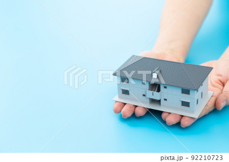 マンションの模型を持つミドル女性の手 92210723