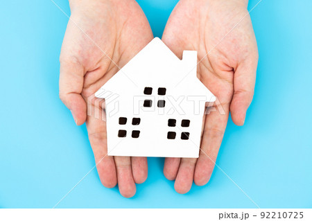 家の住宅模型を持つミドル女性の手 92210725