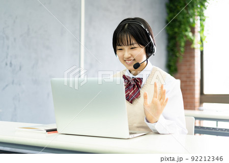 ヘッドセットを付けてパソコンで学習する女子生徒 92212346