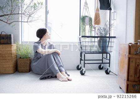 明るい植物のある窓辺の部屋で座って空を見上げて休憩する日本人女性 明るい植物のある窓辺の部屋で座って空を見上げて休憩する日本人女性 92215266