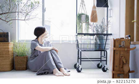 明るい植物のある窓辺の部屋で座って空を見上げて休憩する日本人女性 明るい植物のある窓辺の部屋で座って空を見上げて休憩する日本人女性 92215270