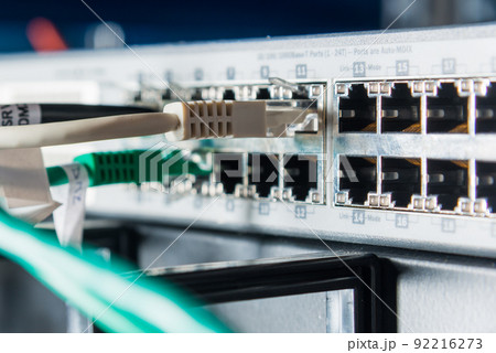Detail of server with patch cables plugged in ethernet ports Detail of server with patch cables plugged in ethernet ports 92216273