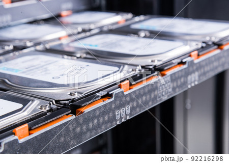 close up of hard disk drives inside hosting center - server rack filled with trays full of data storage drives close up of hard disk drives inside hosting center - server rack filled with trays full of data storage drives 92216298