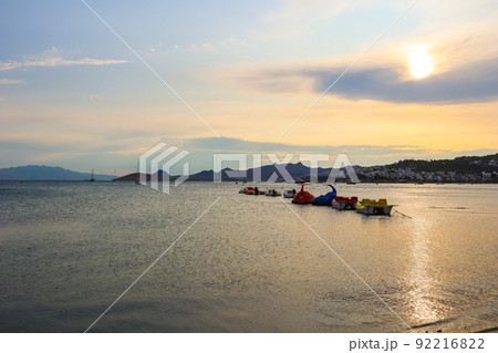Beautiful sunset on Mediterranean coast with islands and mountains, boats and catamarans Beautiful sunset on Mediterranean coast with islands and mountains, boats and catamarans 92216822