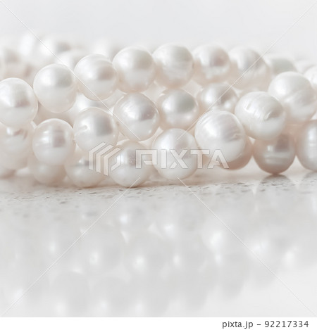 Nature white string of pearls on marble background in soft focus, with highlights Nature white string of pearls on marble background in soft focus, with highlights 92217334