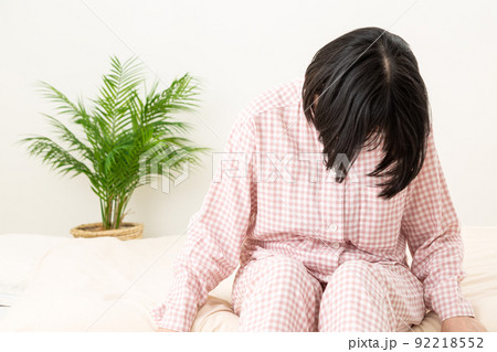 パジャマを着て寝室で落ち込むミドル女性 パジャマを着て寝室で落ち込むミドル女性 92218552