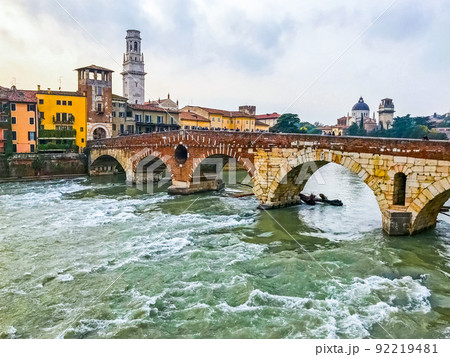 View of the old historical stone bridge Ponte Pietra and Adige river in center of the city Verona. Italy View of the old historical stone bridge Ponte Pietra and Adige river in center of the city Verona. Italy 92219481