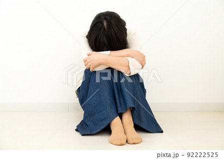 室内の床に座って悲しむミドル女性 室内の床に座って悲しむミドル女性 92222525