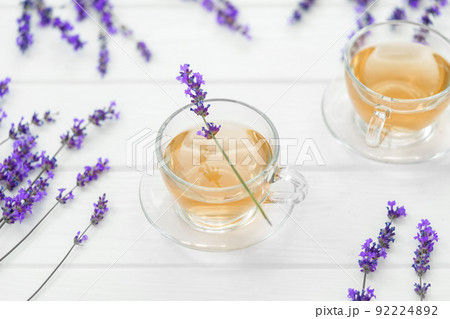 Cup with lavender tea and lavender flowers on wooden backgorund. Cup with lavender tea and lavender flowers on wooden backgorund. 92224892