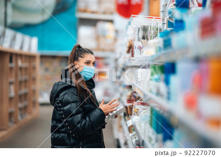Woman with face mask buying during virus pandemic. Woman with face mask buying during virus pandemic. 92227070