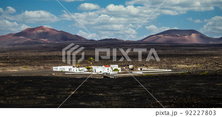 Amazing panoramic landscape of volcano craters in Timanfaya national park. Popular touristic village in La Gueria, Lanzarote island, Canary islans, Spain. Artistic picture Amazing panoramic landscape of volcano craters in Timanfaya national park. Popular touristic village in La Gueria, Lanzarote island, Canary islans, Spain. Artistic picture 92227803