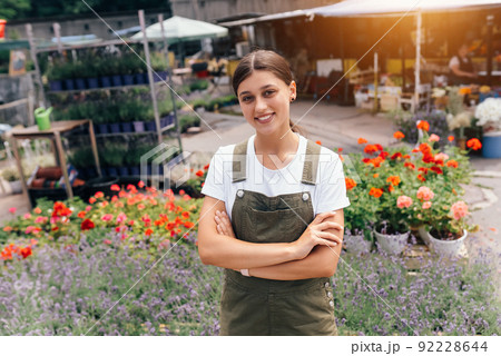 Young woman standing in front of a counter with flowers 92228644