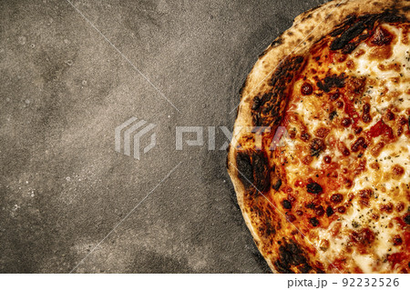 Pizza food background. Homemade Neapolitan pizza Margherita with mozzarella cheese and tomato sauce on a rustic black table. Italian food. Pizza food background. Homemade Neapolitan pizza Margherita with mozzarella cheese and tomato sauce on a rustic black table. Italian food. 92232526