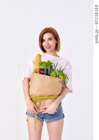 sporty woman holding a shopping bag full of groceries 92238169