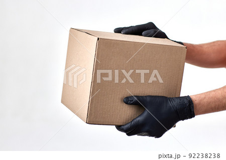 Delivery man hand in gloves holding package box 92238238