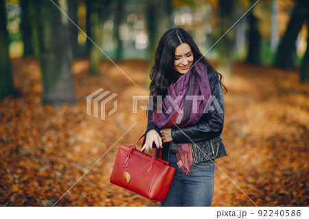 brunette girl relaxing at the park during autumn brunette girl relaxing at the park during autumn 92240586