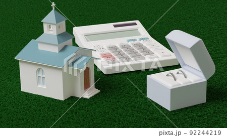 平面上に置かれた指輪とミニチュアのチャペル、電卓の3Dレンダリングイラスト 92244219