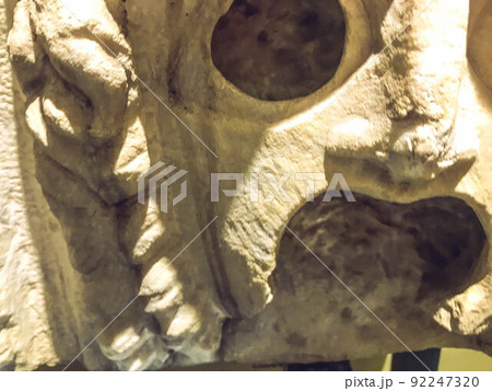 three-dimensional texture, plaster sculpture, ancient art. on the texture of scuffs, chips, cracks. creepy plaster mask with open mouth and large eye sockets 92247320