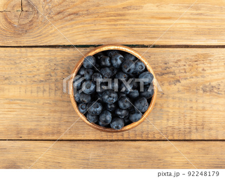 Fresh blueberries in the bowl on a wooden table. Fresh blueberries in the bowl on a wooden table. 92248179