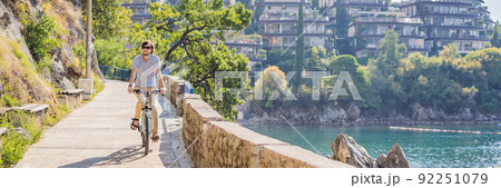 Man tourist on a bicycle explores Budva in Montenegro. Cycling in Montenegro concept BANNER, LONG FORMAT 92251079