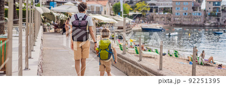 Dad and son tourists walks along the coast of Budva in Montenegro BANNER, LONG FORMAT Dad and son tourists walks along the coast of Budva in Montenegro BANNER, LONG FORMAT 92251395