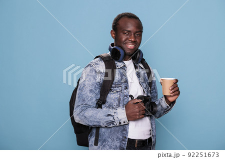 Joyful professional photographer having DSLR camera and voyage backpack going on urban cityscape trip. African american tourist with photo device and rucksack going on weekend holiday journey. Joyful professional photographer having DSLR camera and voyage backpack going on urban cityscape trip. African american tourist with photo device and rucksack going on weekend holiday journey. 92251673