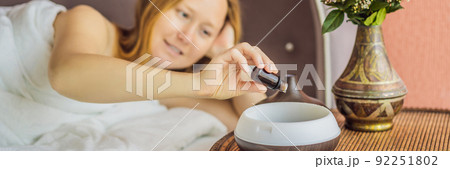 BANNER, LONG FORMAT Aromatherapy Concept. Wooden Electric Ultrasonic Essential Oil Aroma Diffuser and Humidifier. Ultrasonic aroma diffuser for home. Woman resting at home 92251802