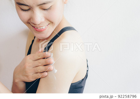 Portrait of young Asian woman applying sunscreen lotion on her body for protect her skin. 92258796