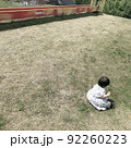 芝生に座るワンピースを着た女の子 92260223