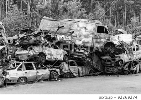 Dump of war-destroyed cars in Ukraine, black and white photo 92269274