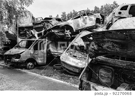 Dump of war-destroyed cars in Ukraine, black and white photo 92270068