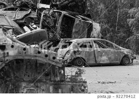 Dump of war-destroyed cars in Ukraine, black and white photo 92270412