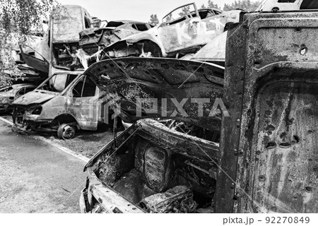 Dump of war-destroyed cars in Ukraine, black and white photo 92270849
