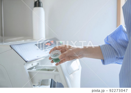 洗濯する女性　洗剤を入れる 92273047