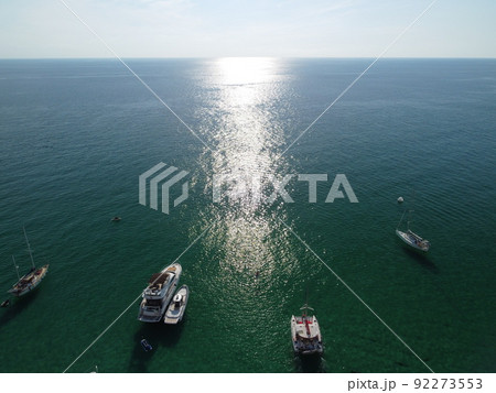 Aerial panoramic view of seascape with crystal clear azure sea and rocky shores. Yachts in a beautiful lagoon on backdrop of rocks. The concept of an ideal destination for summer travel and vacation. Aerial panoramic view of seascape with crystal clear azure sea and rocky shores. Yachts in a beautiful lagoon on backdrop of rocks. The concept of an ideal destination for summer travel and vacation. 92273553